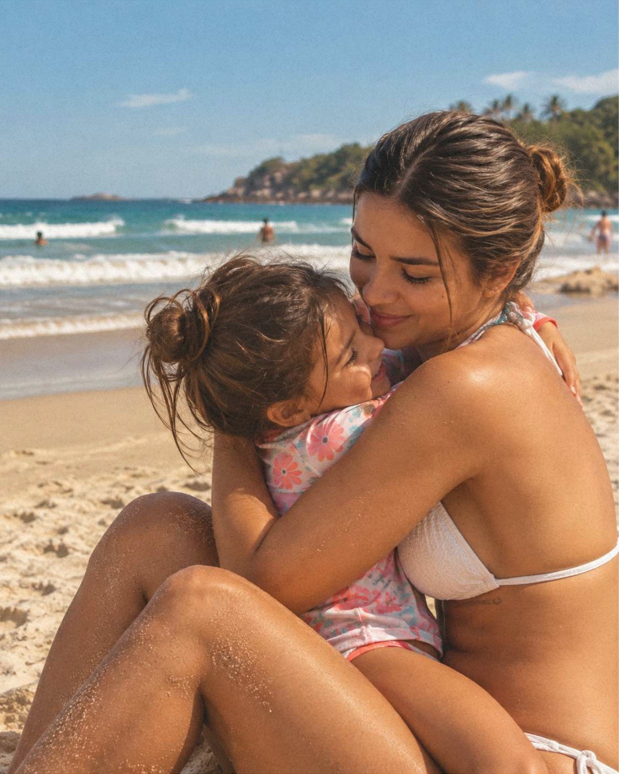 Mãe e filha compartilhando um momento de carinho na praia